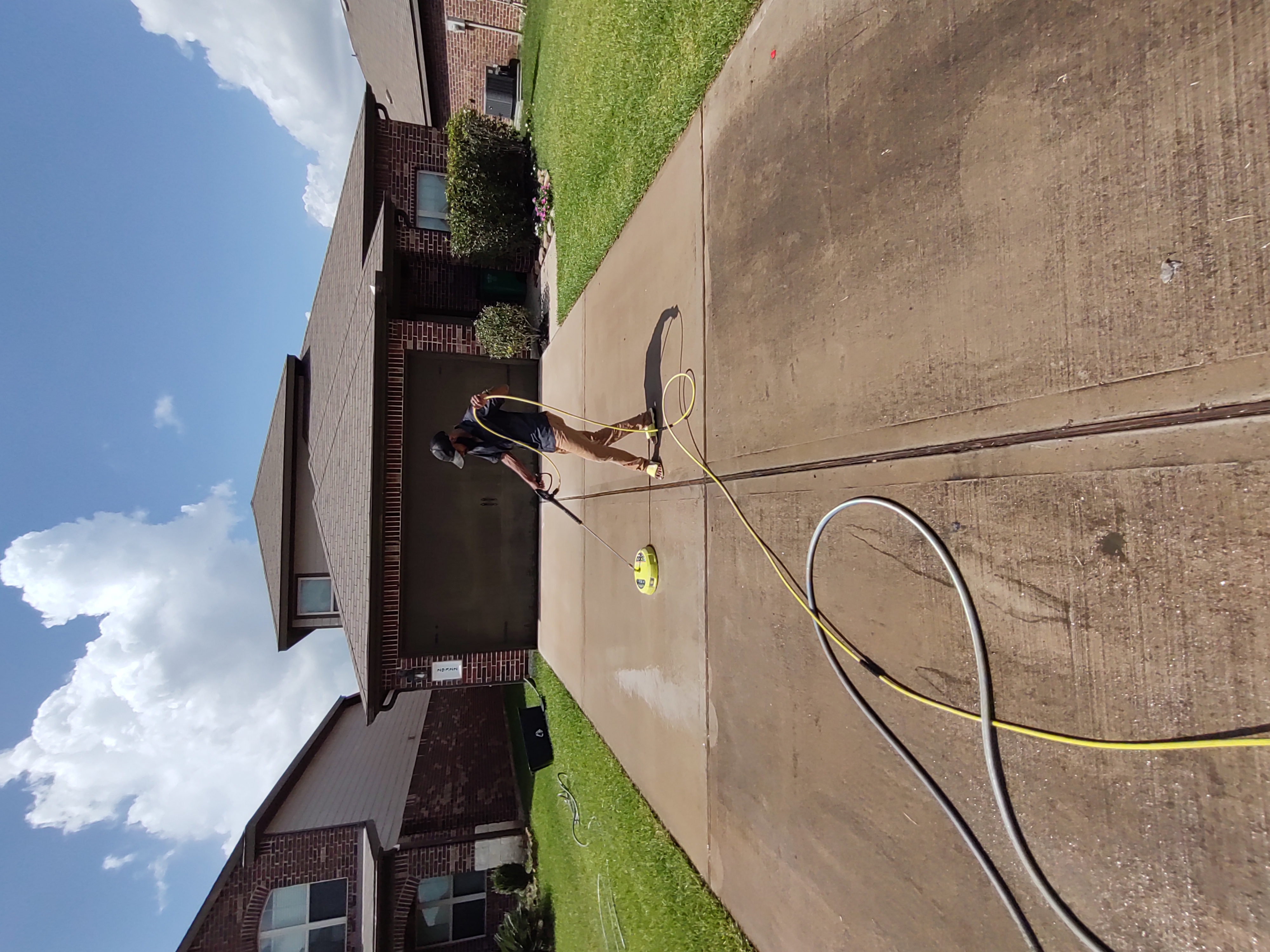 Northrock Exteriors technician pressure washing a concrete driveway in Cypress TX